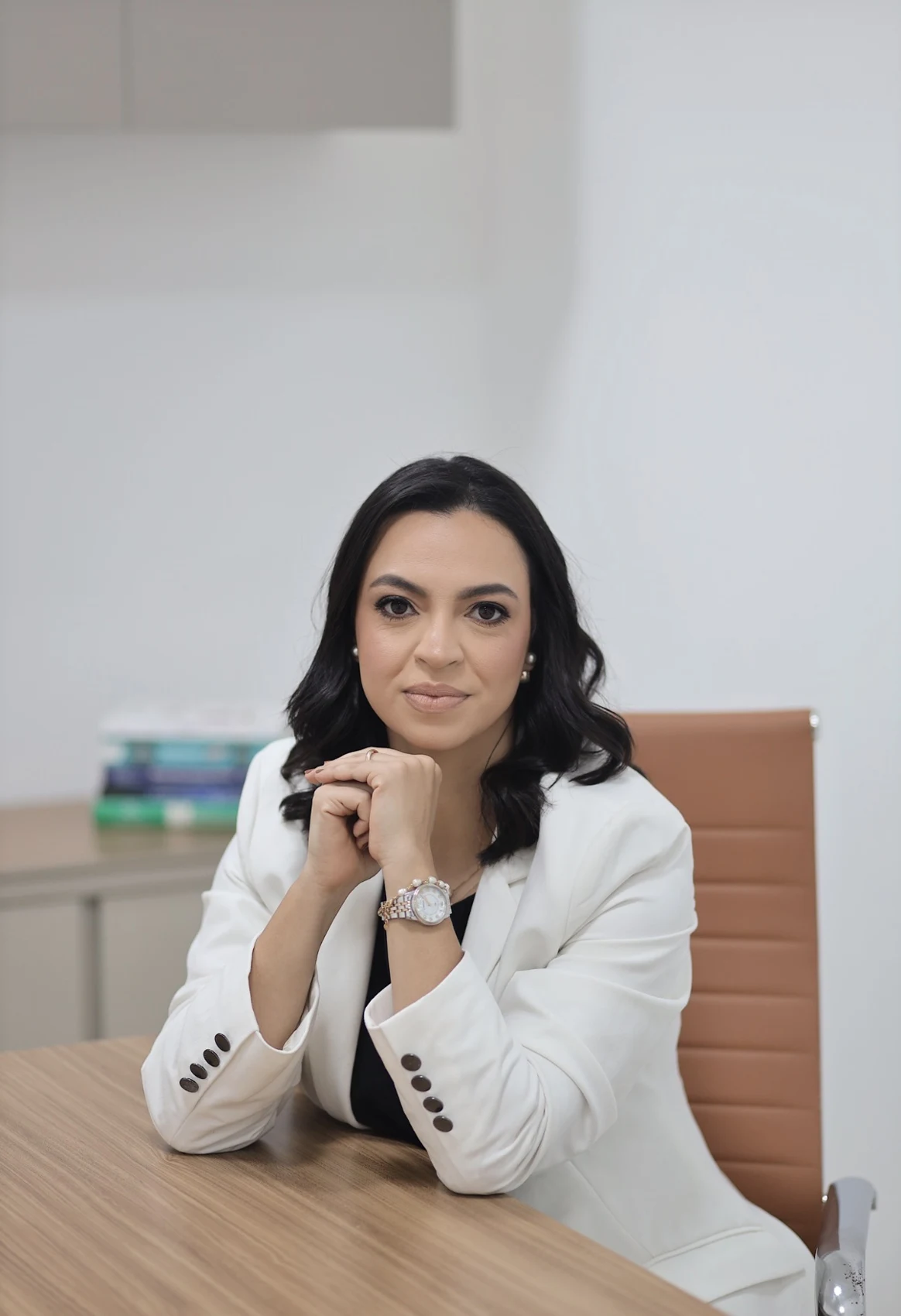 Dra. Ana Cláudia sentada em seu consultório