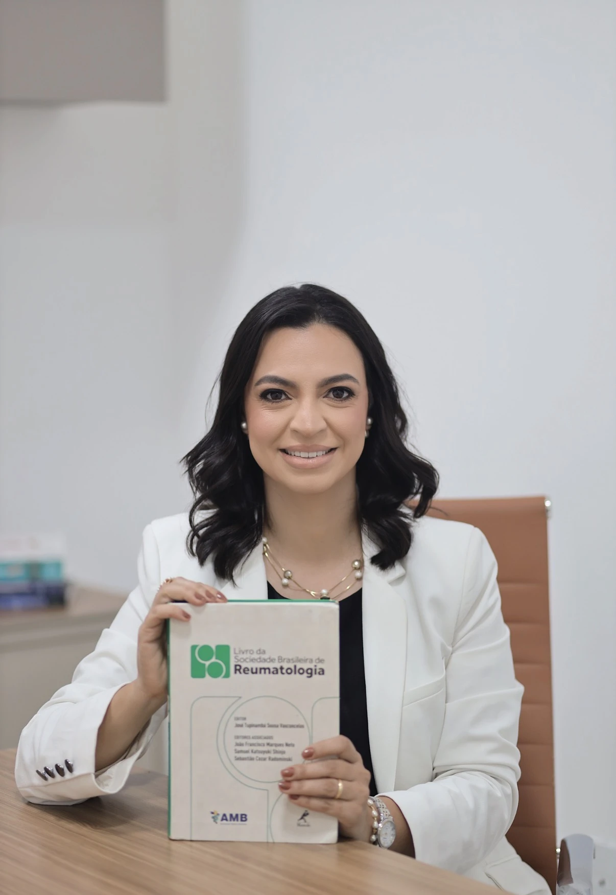 Dra. Ana Cláudia com o Livro da Sociedade Brasileira de Reumatologia